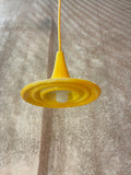 Suspension Ondine Jaune Soleil vue de dessous, avec reliefs circulaires en céramique et ampoule visible. 
