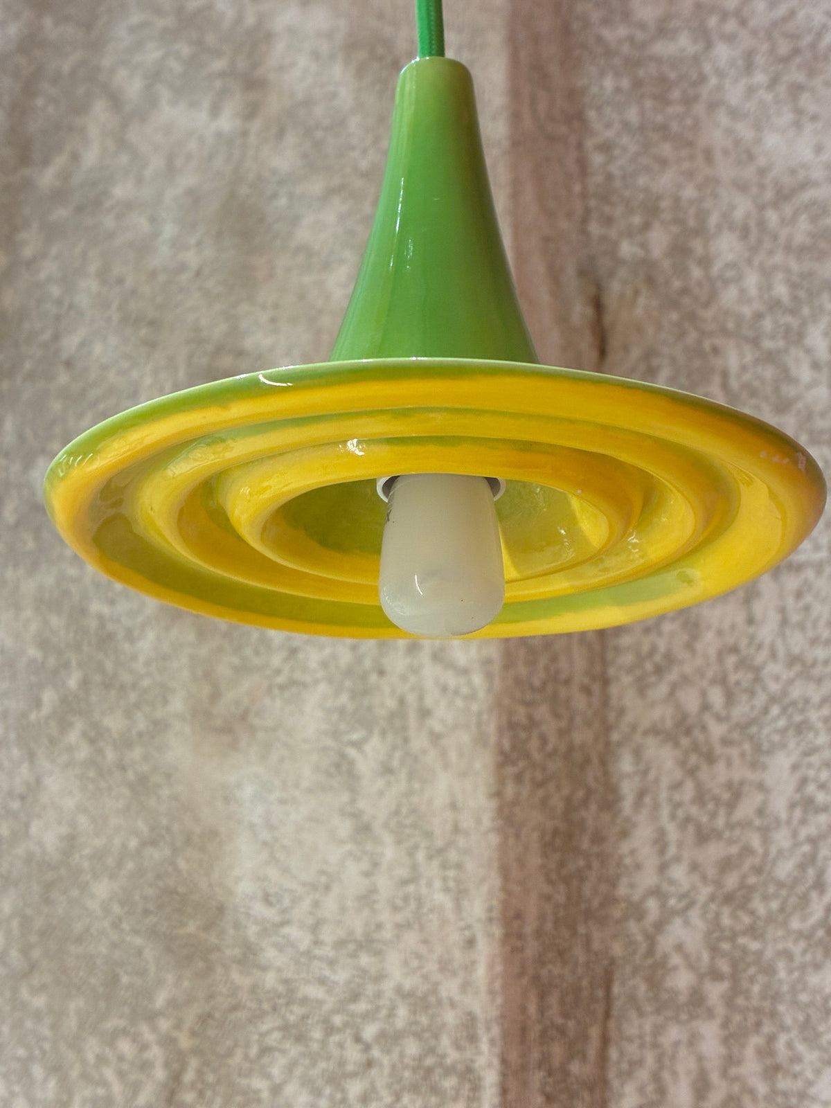 Suspension Ondine vue de dessous, avec reliefs circulaires Jaune Soleil, partie supérieure verte et ampoule. 